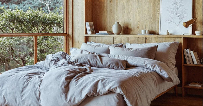 Deux couettes individuelles sur un lit double dans une chambre scandinave